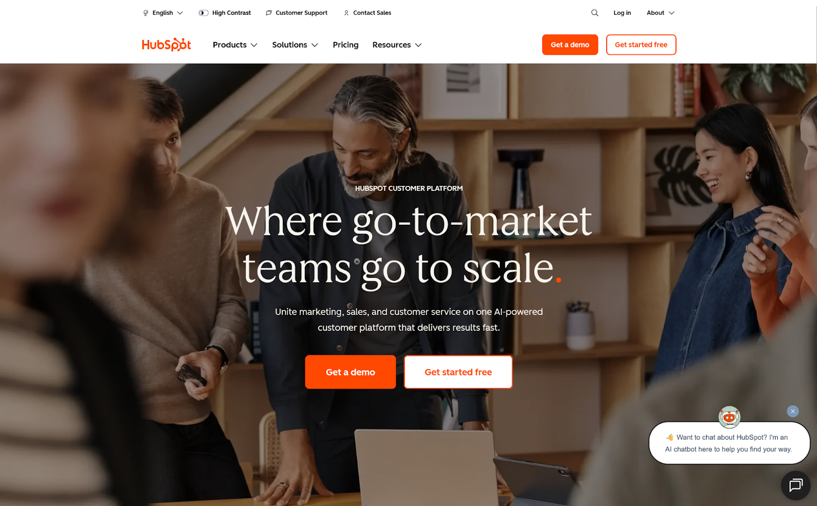 Screenshot of the HubSpot homepage, featuring a photo of a marketing team behind buttons for "Get a demo" and "Get started free