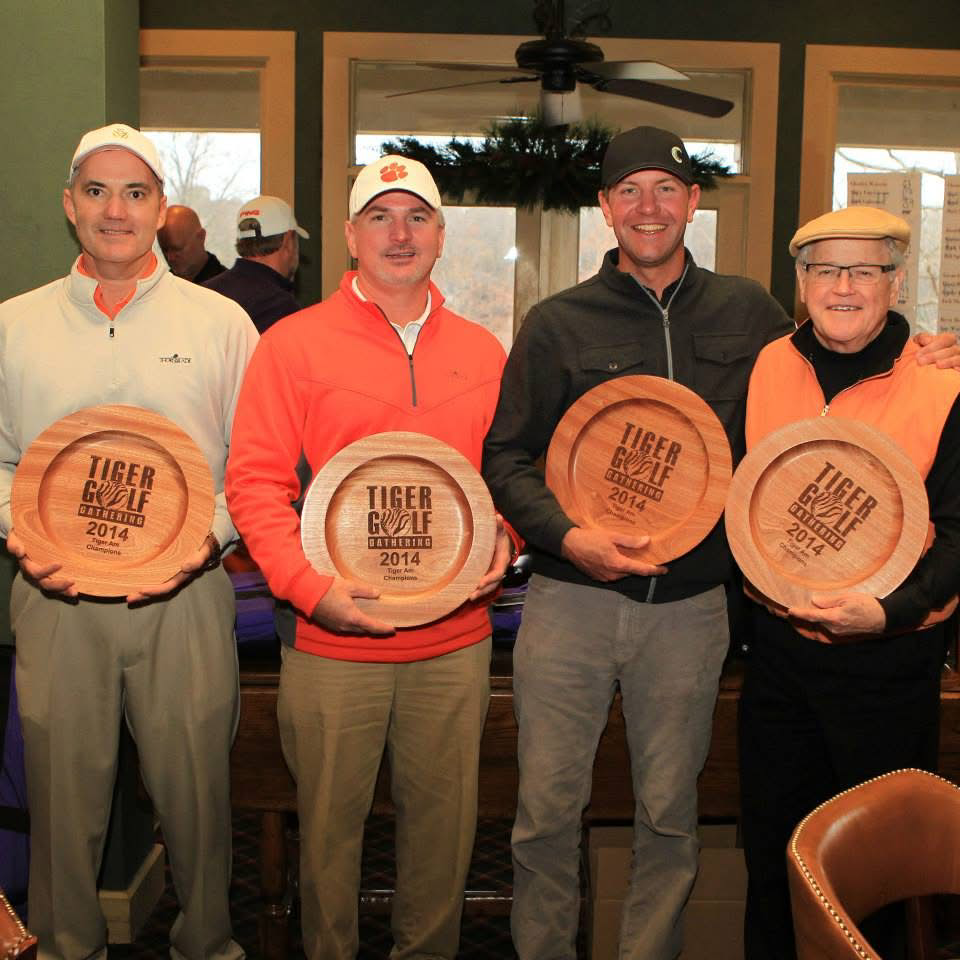 Image of the Clemson golf community members holding a wood plate on their hands